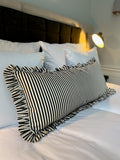 Black and white striped ruffle pillow on a bed villa copenhagen