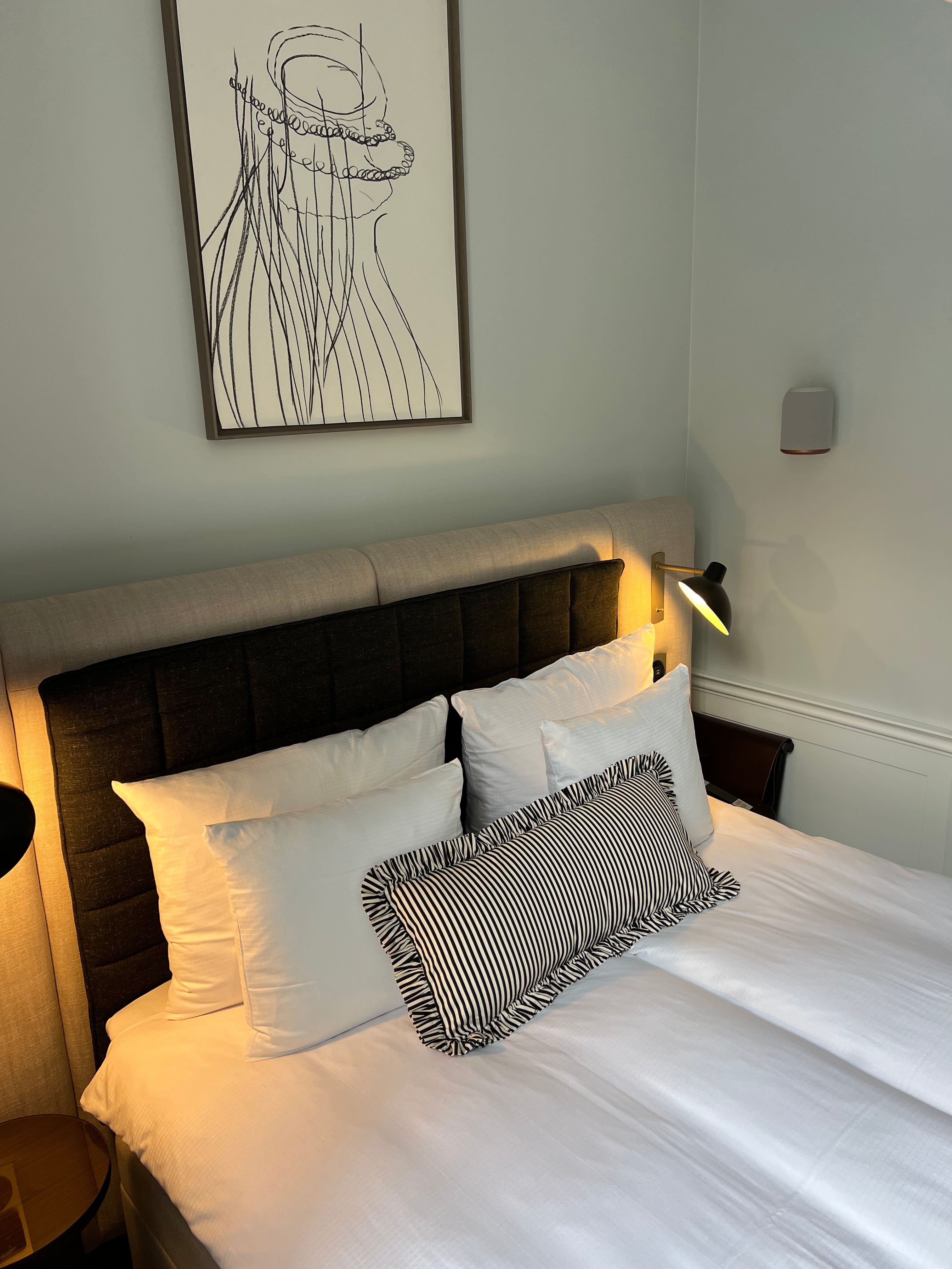 Black and white striped ruffle pillow on a bed villa copenhagen