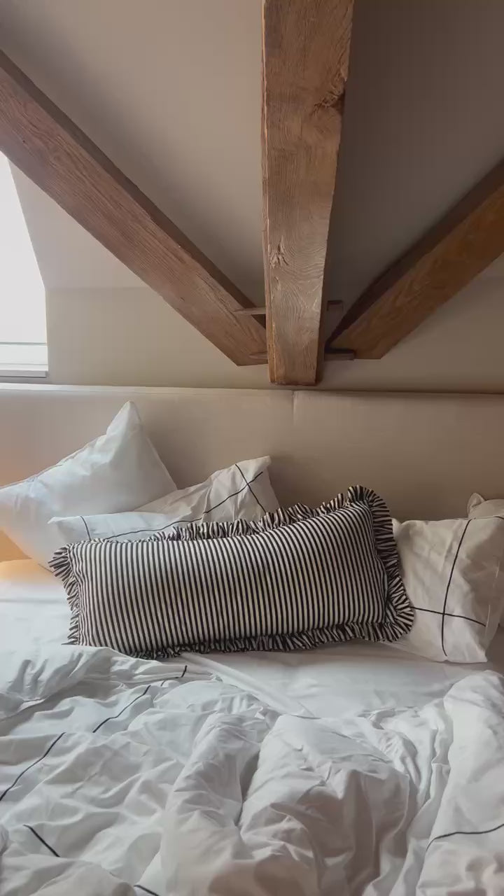 Stripped ruffle pillows on hotel bed